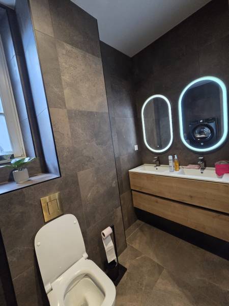 Double vasque avec miroirs LED ovales et carrelage grand format